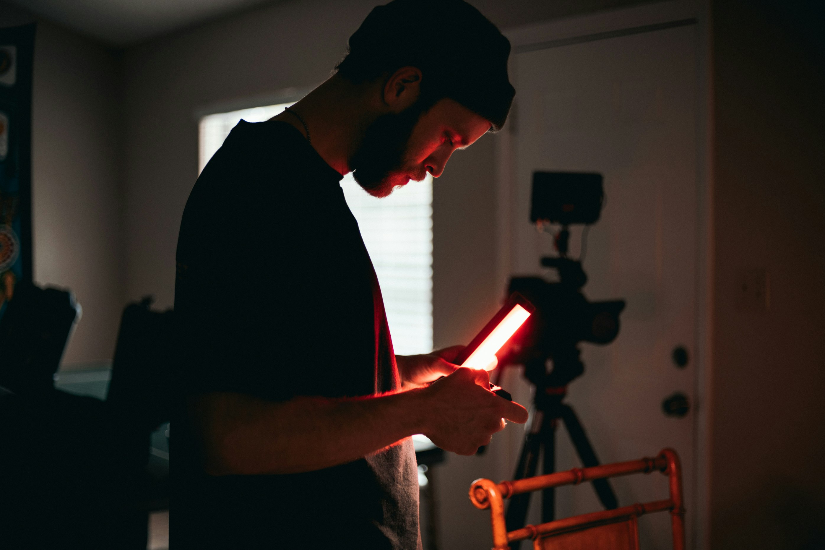 man in black crew neck t-shirt holding red hair blower